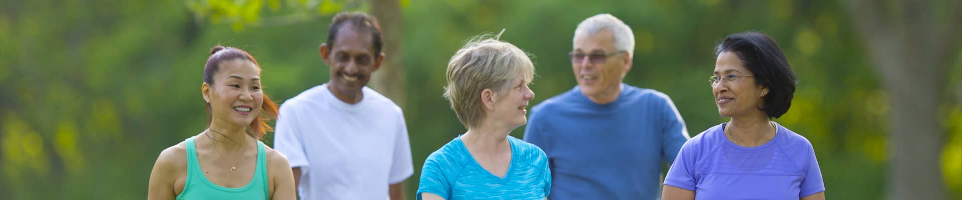 Promisecare Medical Group - A group of people participating in the Staying Healthy Assessment Questionnaires (SHA) while walking in a park.