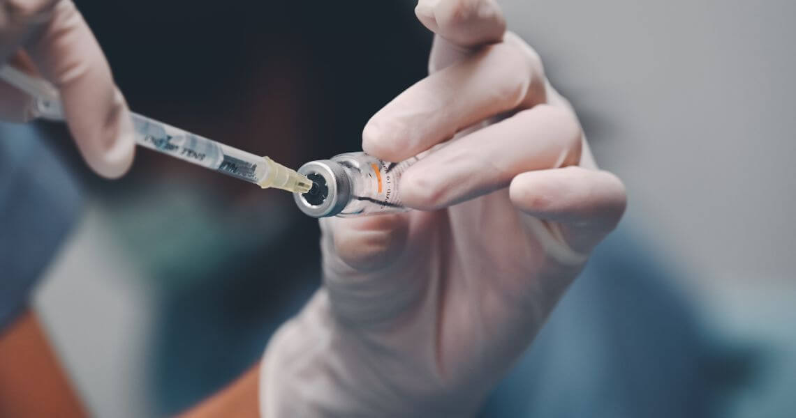 Promisecare Medical Group - A hand holding a syringe and needle.