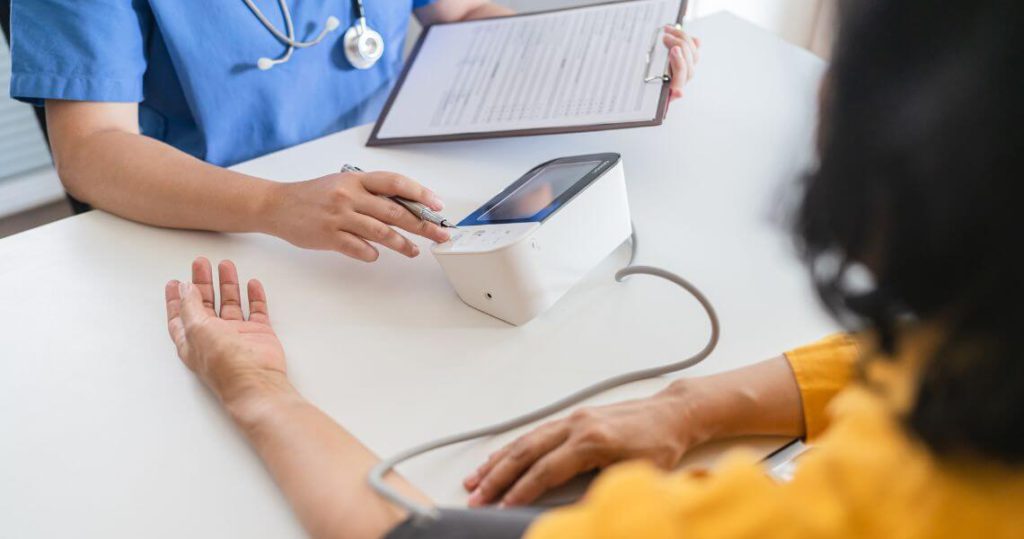 Promisecare Medical Group - A nurse is taking a patient's blood pressure.