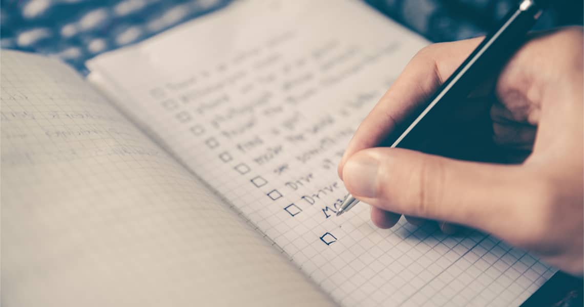 Promisecare Medical Group - A person writing on a notebook with a pen.