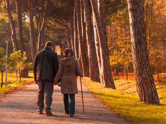 Promisecare Medical Group - A couple walking down a path in the woods.