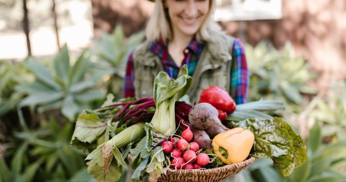 Promisecare Medical Group - A woman holding a basket full of fresh vegetables in a garden.
