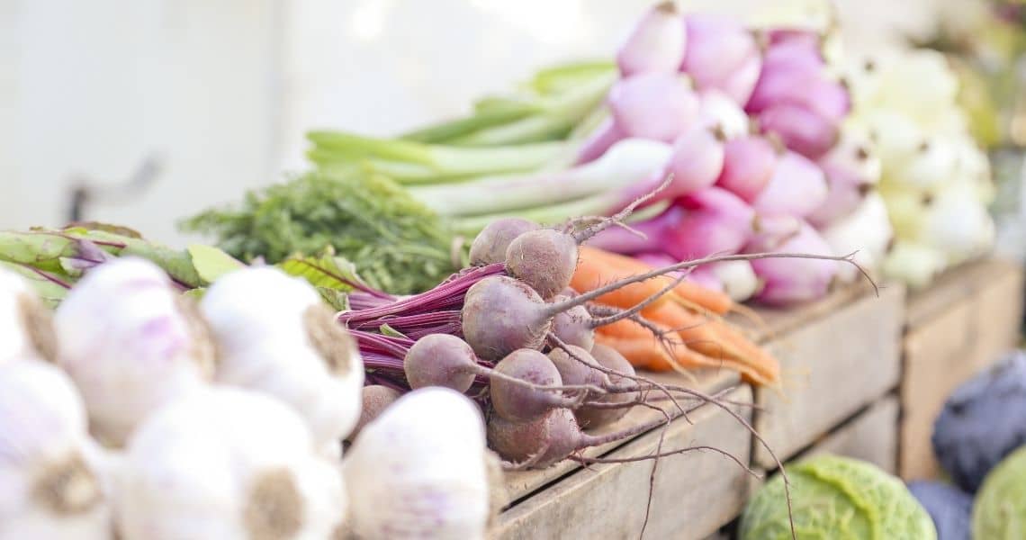 Promisecare Medical Group - Assorted fresh vegetables displayed on a wooden market stall.