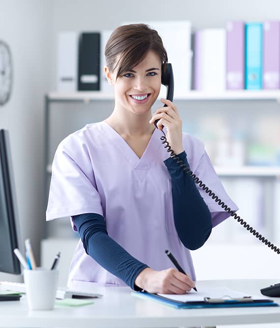 Promisecare Medical Group - A nurse at her desk, using a Footer Template while talking on the phone.