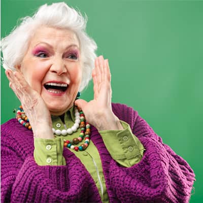 Promisecare Medical Group - During the Medicare Annual Enrollment Period, a woman wearing a purple sweater calmly holds her hands up in an expressive gesture.