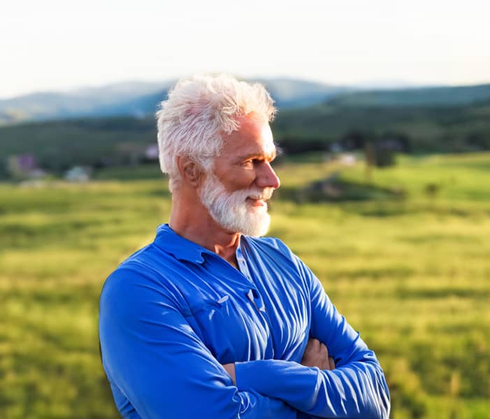 Promisecare Medical Group - A man with a white beard standing in a field during the Medicare Annual Enrollment Period for 2024.