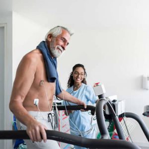 Promisecare Medical Group - An older man and a nurse have their annual wellness physical while using a treadmill.