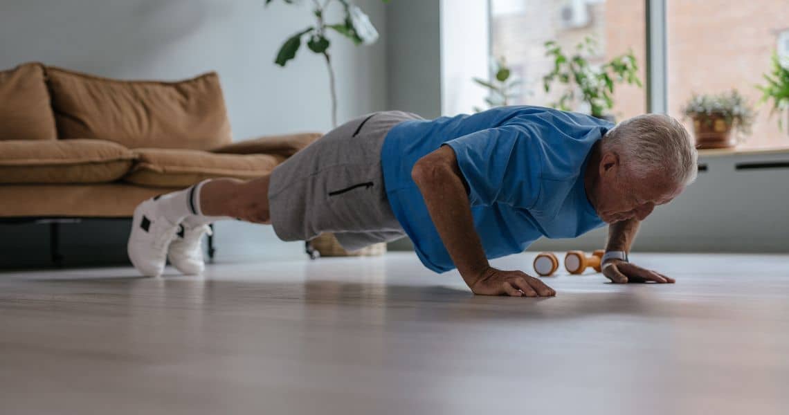Promisecare Medical Group - An older man doing push ups in his living room.