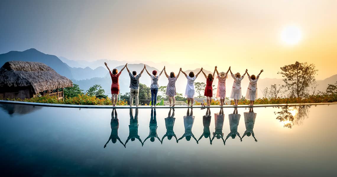 Promisecare Medical Group - A group of people standing in front of a pool at sunset.