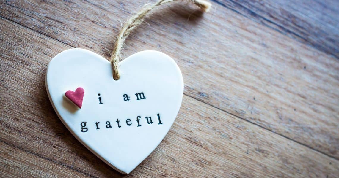 Promisecare Medical Group - A heart with the words i am grateful hanging on a wooden surface.