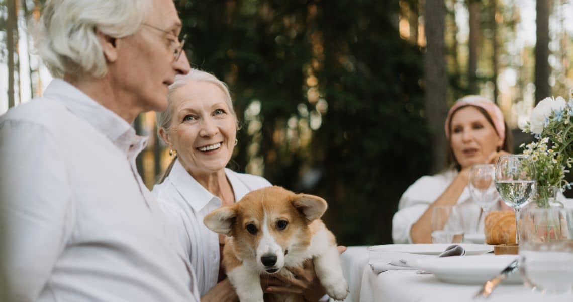 Promisecare Medical Group - An older couple with a dog sitting at a table.