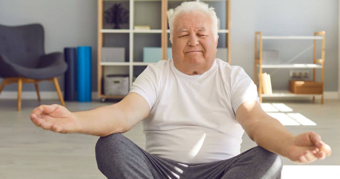 Promisecare Medical Group - An older man meditating in his living room.
