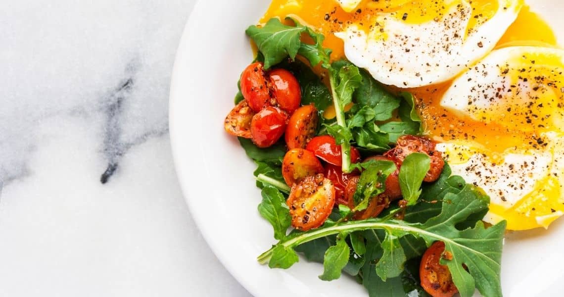 Promisecare Medical Group - A plate with a poached egg, arugula, and roasted cherry tomatoes.